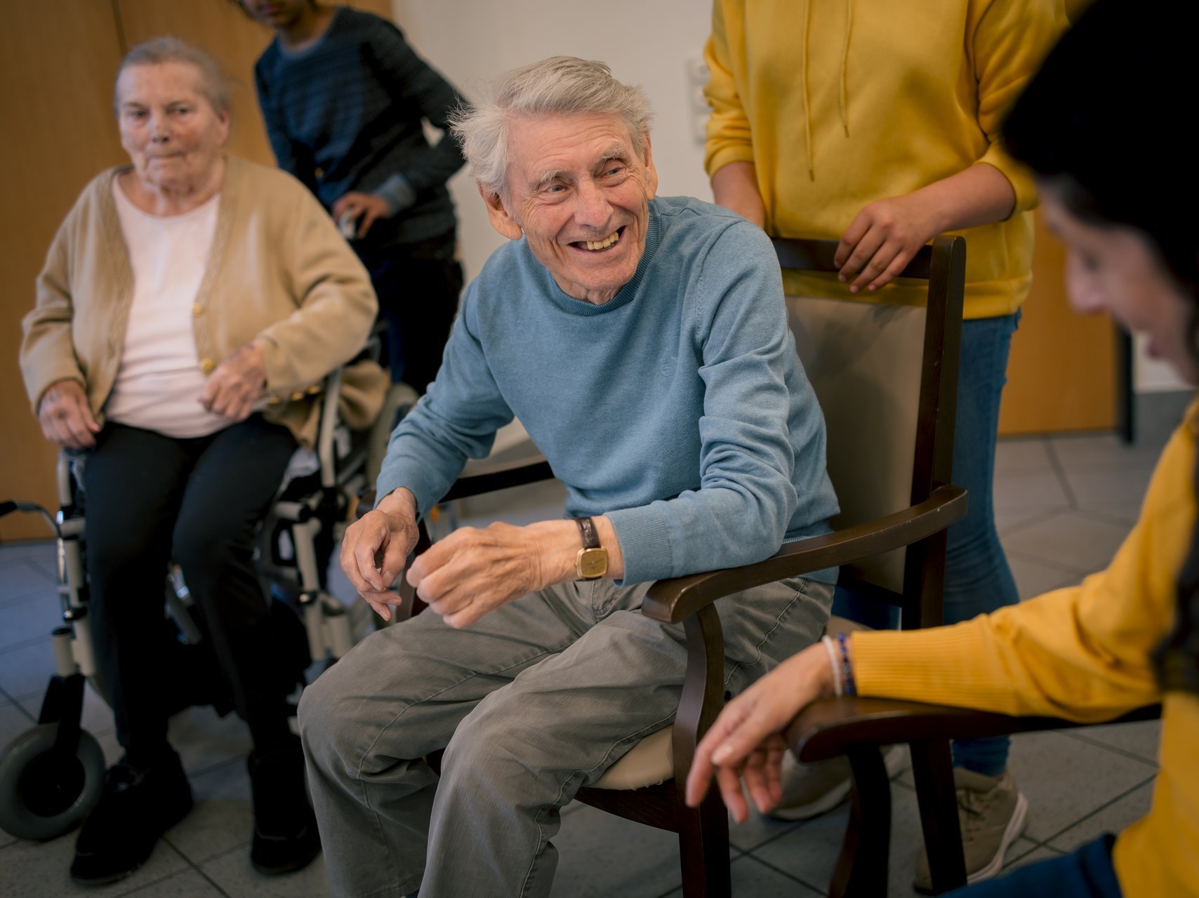 Eine Gruppe von Bewohnenden und Mitarbeitenden unterhält sich lachend.