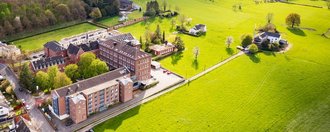 Luftaufnahme von Haus St. Raphael, umgeben von Wiesen und Wäldern.